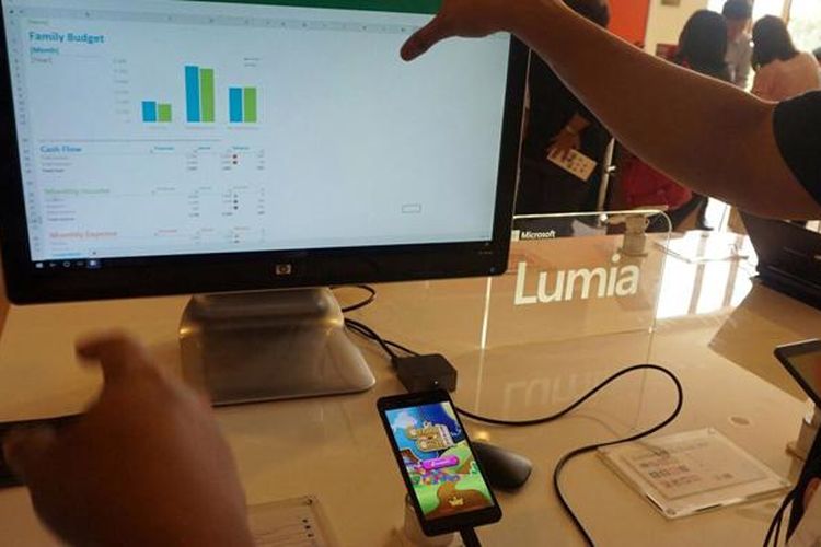 Smartphone Lumia 950 tetap bisa digunakan secara normal saat terhubung dengan monitor eksternal. Di foto ini nampak file Excel dibuka di monitor dan game Candy Crush sedang dimainkan di smartphone.