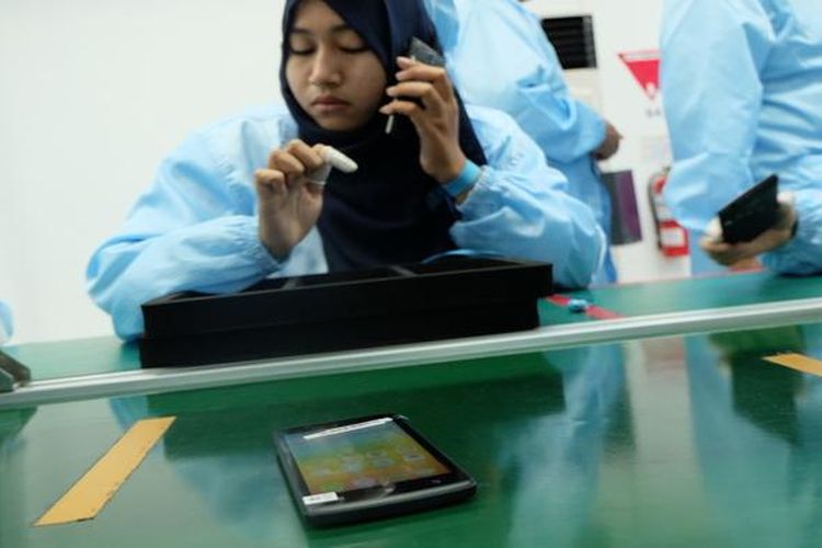 Seorang karyawan menguji fungsi speaker ponsel Lenovo yang dirakit di PT. Tridharma Kencana (TDK) di Serang, Banten.