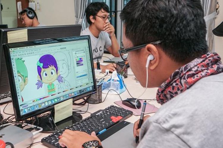 Seorang ilustrator tampak serius mengerjakan desain karakter untuk game Educa Studio