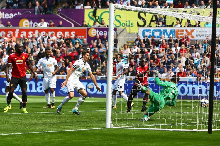 Bek Manchester United asal Pantai Gading, Eric Bailly (2 dari kanan), mencetak gol pertama timnya ke gawang Swansea City yang dikawal kiper asal Polandia, Lukasz Fabianski, dalam pertandidngan Premier League di Liberty Stadium, Sabtu (19/8/2017). Tampak striker Belgia, Romelu Lukaku (kiri), memandang gol yang dihasilkan rekannya tersebut.