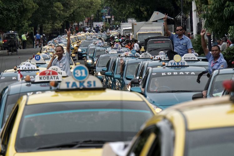 Sejumlah tukang ojek, taksi, dan angkutan kota konvensional, melakukan unjuk rasa menolak keberadaan transportasi daring (online), di Alun-alun Purwokerto, Banyumas, Jawa Tengah, Selasa (17/10/2017). Para pekerja transportasi konvensional yang tergabung dalam Forum Transportasi Banyumas (FORTAS), melakukan mogok dan unjuk rasa menuntut agar Pemkab Banyumas mengeluarkan aturan yang melarang keberadaan transportasi online.