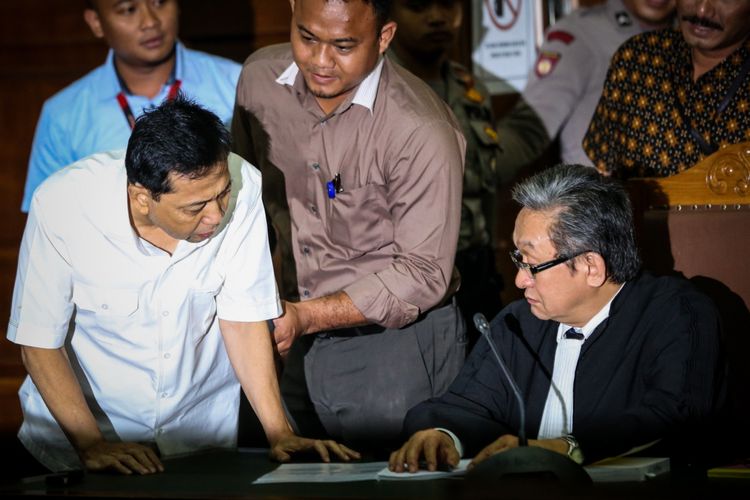 Tersangka kasus korupsi proyek e-KTP, Setya Novanto berbicara dengan penasehat hukumnya pada sidang perdana di Gedung Pengadilan Tipikor, Jakarta, Rabu (13/12/2017). Setya Novanto akan menghadapi sidang pembacaan dakwaan oleh jaksa penuntut umum.