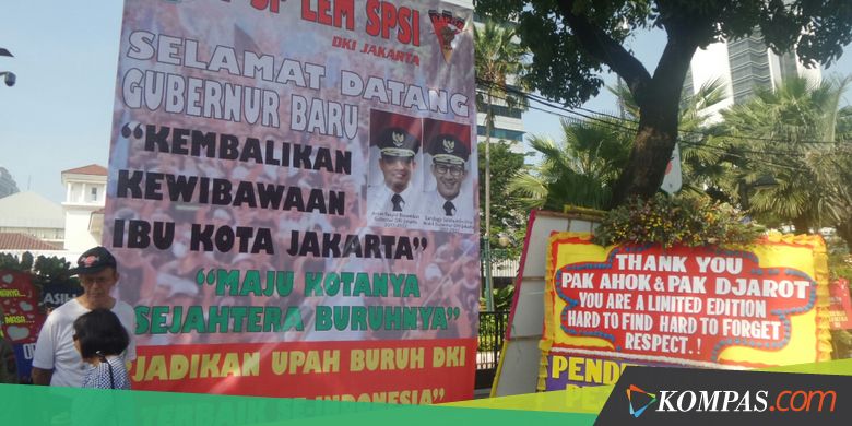 Spanduk "Selamat Datang Gubernur Baru" Dekat Karangan Bunga Ahok-Djarot