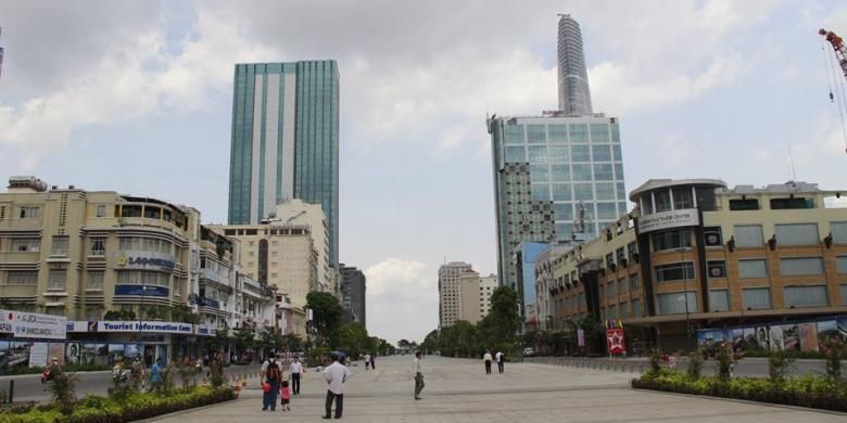 Plaza di kota Ho Chi Minh yang diapit gedung-gedung komersial perkantoran dengan latar belakang Bitexco Financial Tower.