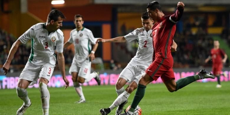 Kapten timnas Portugal, Cristiano Ronaldo (kanan), melepaskan tembakan di antara kepungan pemain Bulgaria dalam laga uji coba di Leiria, 25 Maret 2016.