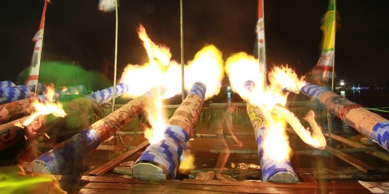 Suasana kemeriahan permainan meriam karbit di tepi Sungai Kapuas saat malam takbiran.