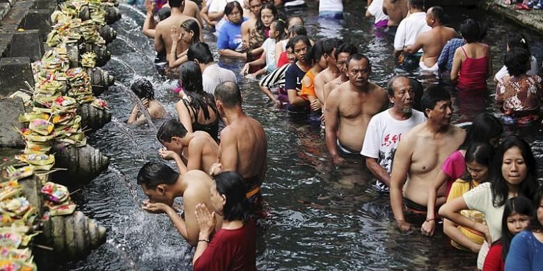Umat Hindu dan wisatawan mengantre untuk menikmati kesegaran air pancuran di obyek wisata pemandian suci Tirta Empul yang menjadi satu kompleks dengan Istana Tampaksiring di Ubud, Bali, Minggu (7/8/2016). Potensi wisata alam dan adat menjadi andalan pariwisata Gianyar.