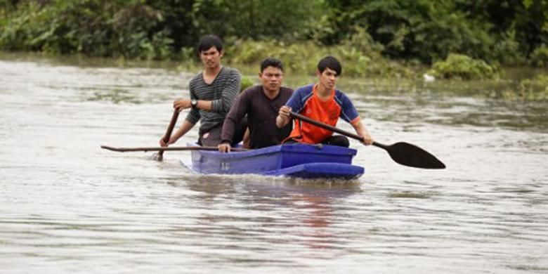 Petugas penyelamat sedang mencari dua bocah yang dikabarkan hanyut di sungai yang meluap saat banjir melanda wilayah selatan Thailand, di Provinsi Pattani, Selasa (6/12/2016).  