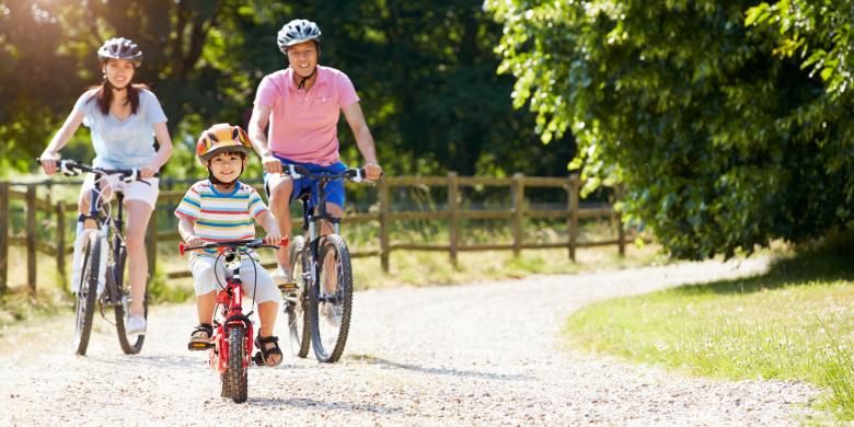 Anak bermain sepeda bersama orangtua