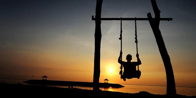Cara lain menikmati kehangatan matahari terbit di pantai Sanur, Bali, Senin (20/2/2017).