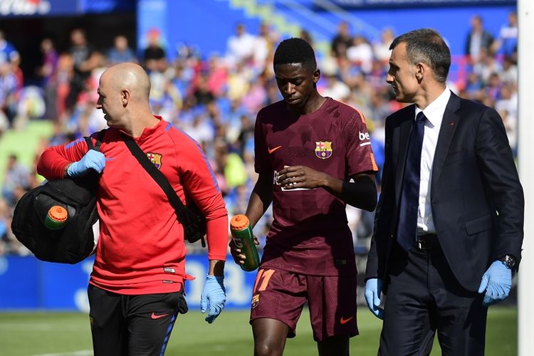 Penyerang Barcelona, Ousmane Dembele (tengah), berjalan bersama dokter tim dalam pertandingan La Liga melawan Getafe di Stadion Col. Alfonso Perez, Getafe, 16 September 2017.
