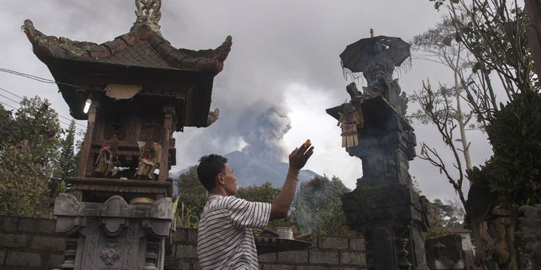 Warga berdoa di rumahnya di Desa Besakih, Karangasem, Bali, Selasa (28/11/2017). Pusat Vulkanologi dan Mitigasi Bencana Geologi memantau kolom abu gunung bertambah tinggi hingga 4.000 meter dalam enam jam terakhir sejak pukul 06.00 Wita pada Selasa (28/11/2017).