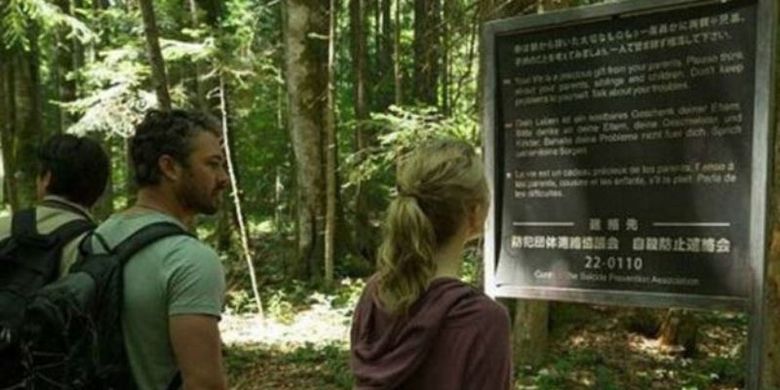 Film The Forest (2016) memperlihatkan plang imbauan tidak bunuh diri di Hutan Aokigahara. (Foto: Gramercy Pictures)