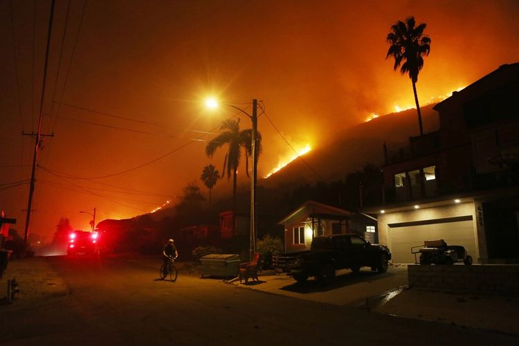 Peseoada melewati jalanan di dekat kobaran Api Thomas, pada Kamis (7/12/2017). di La Conchita, California. (AFP/Mario Tama) 