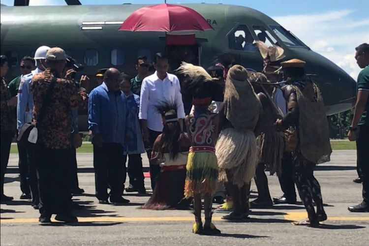 Presiden Joko Widodo dan Ibu Negara Iriana, Rabu (20/12/2017) siang, tiba di Kabupaten Nabire, Papua. Mendarat di  Bandar Udara Douw Aturure, Jokowi dan Ibu Negara disambut tarian, nyanyian dan prosesi adat injak piring masyarakat dari dua suku, yakni Mipago dan Seireri.