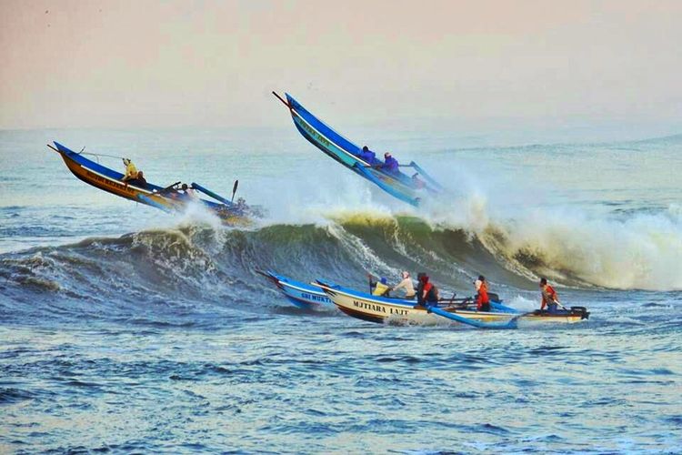 Nelayan menerjang gelombang tinggi saat berangkat melaut di lepas pantai Pandanarang, Cilacap, Jawa Tengah, Rabu (6/9/2017).