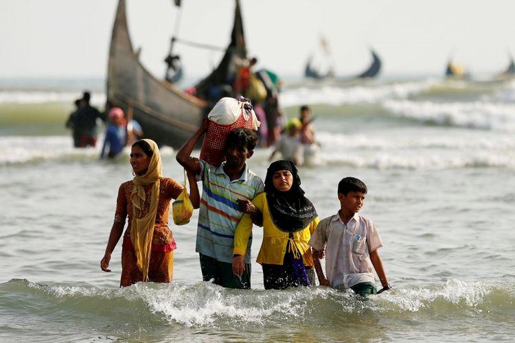Pengungsi Rohingya berjalan menuju pantai dengan harta benda mereka setelah menyebrangi perbatasan Bangladesh-Myanmar menggunakan perahu melalui Teluk Benggala di Teknaf, Bangldesh, Selasa (5/9). (ANTARA FOTO/REUTERS/Mohammad Ponir Hossain)