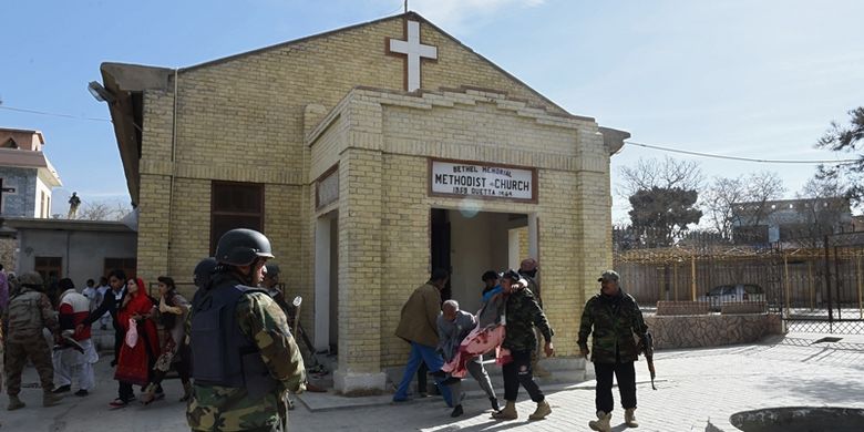 Petugas keamanan Pakistan terlihat sedang menyelamatkan seorang wanita yang terluka setelah pelaku bom bunuh diri menyerang gereja Metodis pada Minggu (17/12/2017), di Quetta, Pakistan.