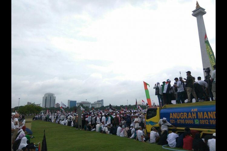 Rumput di kawasan Monas dijaga oleh patugas keamanan ormas.