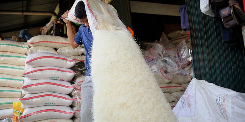 Buruh mencampur beras di Pasar Induk Beras Cipinang, Jakarta Timur, Rabu (26/7/2017). Penetapan Harga Eceran Tertinggi (HET) untuk komoditas beras memberikan pengaruh yang besar kepada para petani dan pedagang sehingga menyebabkan pasokan beras ke pasar induk anjlok.