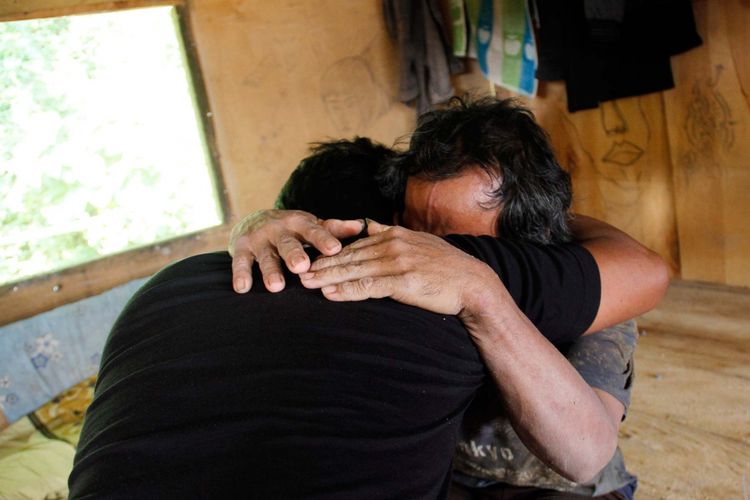 Rekan sesama penambang memeluk Karno (50) dan terharu karena dia bisa berhasil diselamatkan setelah terjebak di dalam lubang tambang emas selama 26 jam.