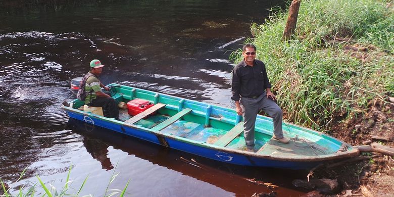 Mahyudin berdiri di atas salah satu perahu yang ia sewakan kepada Riau Andalan Pulp and Papper. Tak lagi mencuri kayu, kini ia mendapat kesempatan kerja sama dengan RAPP juga bantuan pinjaman modal usaha.