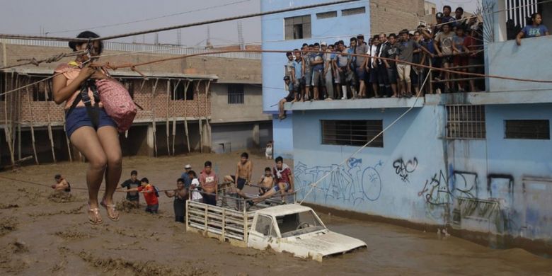 MARTIN MEJIA/ASSOCIATED PRESS

Seorang perempuan dievakuasi melalui seutas tali ke tempat yang lebih aman di Lima, Peru, Jumat (17/3/2017). Banjir menyusul hujan lebat akibat El Nino merusak 115.000 rumah, merobohkan 117 jembatan, dan memutus jalan utama di sejumlah tempat di Peru.