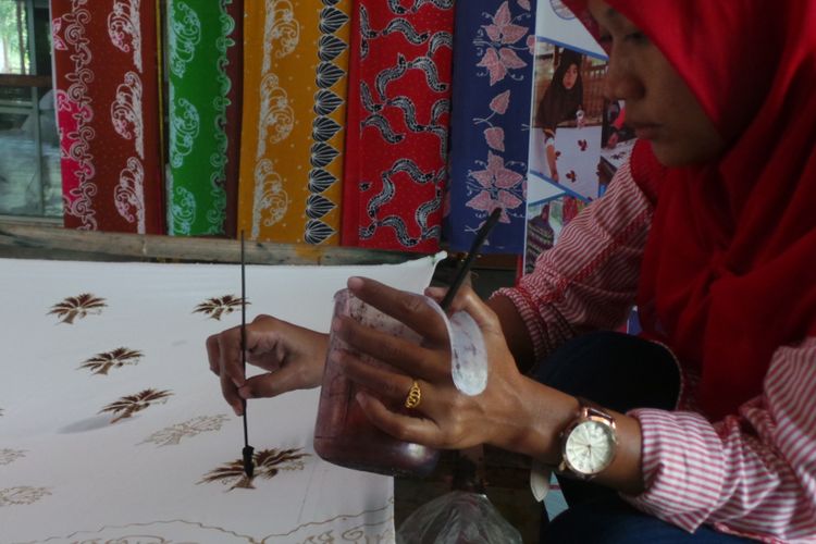 Seorang pembuat batik Riau bernama Ade sedang membuat batik motif sawit. Ade adalah salah satu pegawai yang dilatih dan bekerja di Rumah Batik Andalan.