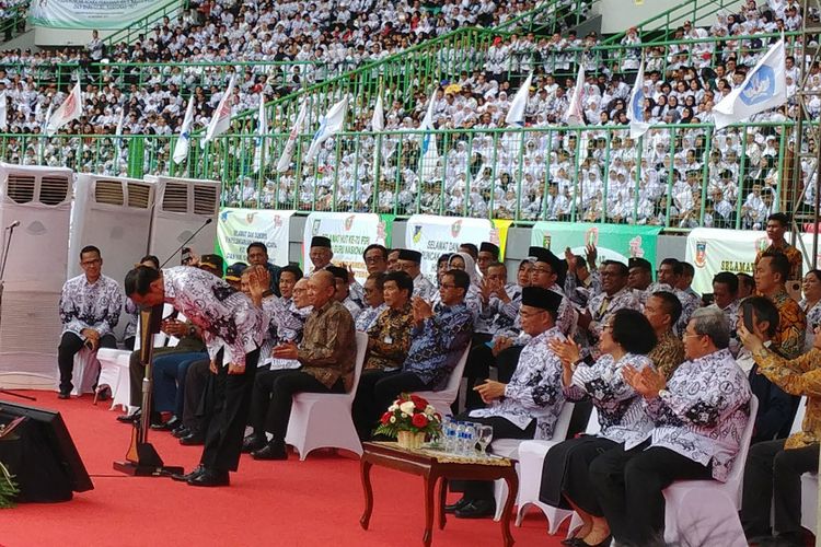 Presiden Joko Widodo menundukkan badan untuk memberi hormat kepada guru yang hadir dalam peringatan hari ulang tahun Persatuan Guru Seluruh Indonesia (PGRI) dan Hari Guru Nasional 2017 di Stadion Patriot Candrabhaga, Bekasi, Sabtu (2/12/2017).