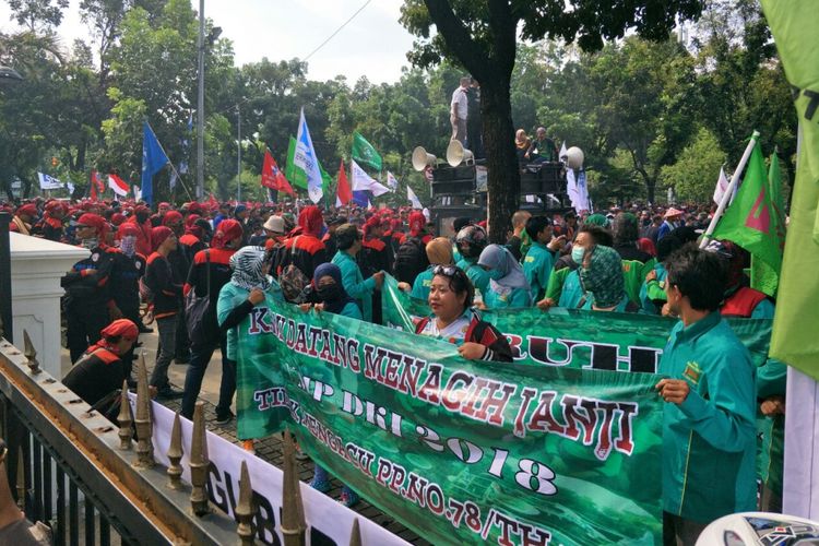 Massa buruh melakukan aksi unjuk rasa memprotes penetapan UMP DKI 2018 di depan Balai Kota DKI Jakarta, Jumat (10/11/2017).