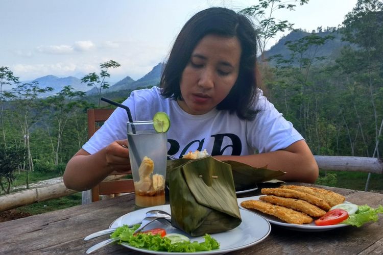 Seorang wisatawan tengah menikmati nasi gegog, kuliner khas Trenggalek. Sentra nasi gegog terletak di Kecamatan Bendungan, Kabupaten Trenggalek, Jawa Timur.