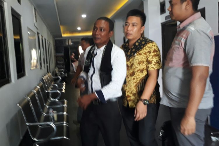 Kakak tersangka pembunuh pegawai BNN, MT (baju putih) saat mendatangi Polres Bogor untuk menjalani pemeriksaan, Jumat (8/9/2017)
