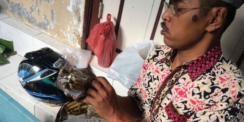 Mardiyono, seorang penjual kue clorot sedang membungkus pesanan dari pelanggan pasar Ramadan Kauman, Yogyakarta, Rabu (7/6/2017).