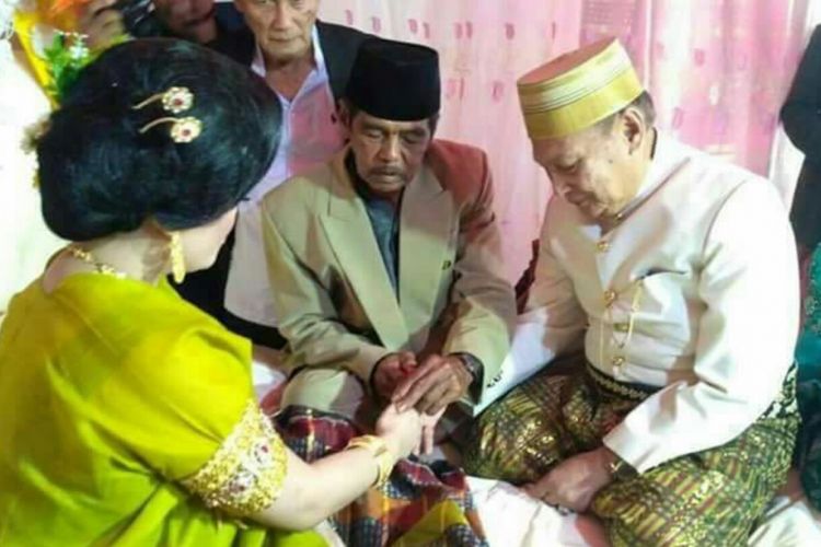 Mempelai pria tengah memasangkan cincin kawin ditengahi penghulu usai ijab kabul digelar antara kekak 70 tahun dengan gadis 25 tahun di Kabupaten Bone, Sulawesi Selatan, Sabtu, (22/4/2017).(KOMPAS.com / ABDUL HAQ