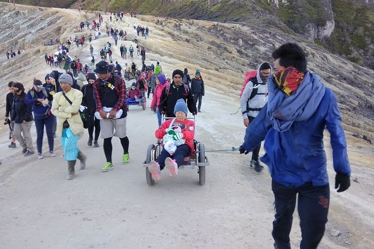 Pengojek atau supir supir taksi mengantarkan wisatawan menuruni jalur pendakian Gunung Ijen, Jawa Timur (9/9/2017). Pengojek atau supir taksi itu akan mengantarkan wisatawan menggunakan gerobak.(KOMPAS.com / WAHYU ADITYO PRODJO)