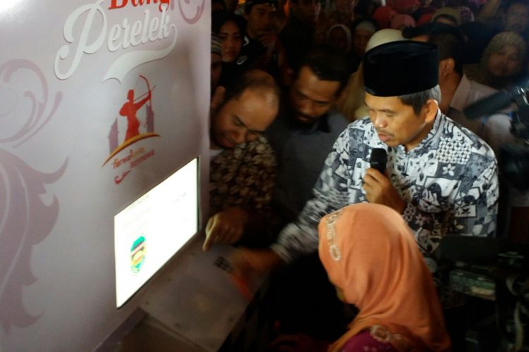 Bupati Purwakarta Dedi Mulyadi dan warga penerima beras perelek gratis mencoba langsung ATM Beras yang diluncurkan bertepatan di Peringatan Hari Lahir Pancasila, Kamis (1/6/2017).