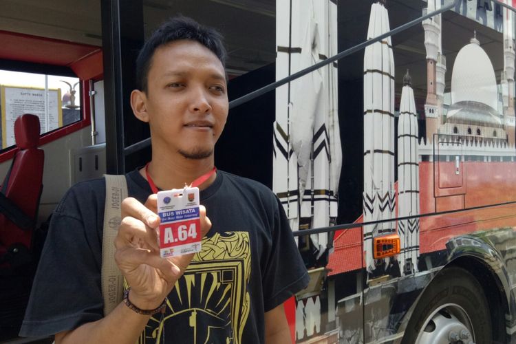 Yusuf (28) salah satu anggota komunitas Busmania wilayah Semarang, memperlihatkan kartu tiket bus tingkat wisata Semarang pada KompasTravel, Jumat (6/9/2017). Setiap perjalanannya wisatawan akan diberi kartu yang berbeda, merah untuk pagi, biru keberangkatan siang, kuning sore, dan hijau trip malam hari.