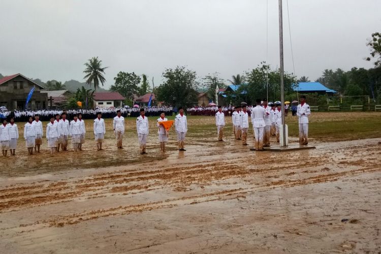 Pasukan pengibar bendera Merah Putih di Kecamatan sebulu, Kutai Kartanegara, tetap melaksanakan tugas di tengah hujan deras dan tanah yang berlumpur