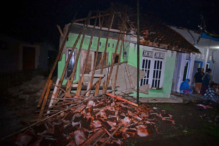 Warga menyaksikan rumah yang ambruk akibat gempa bumi di Desa Sumelap, Kota Tasikmalaya, Jawa Barat, Sabtu (16/12/2017). Gempa berkekuatan 6,9 skala richter dan berpotensi tsunami dilaporkan terjadi pada Jumat (15/12) pukul 23:47:58 WIB di wilayah Tasikmalaya. 