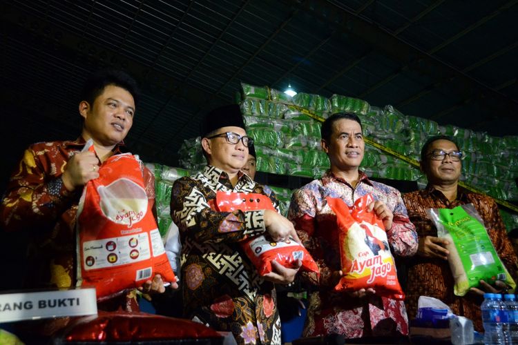Kapolri Jenderal Tito Karnavian (kedua kiri) bersama Menteri Pertanian Amran Sulaiman (kedua kanan), Ketua Komisi Pengawas Persaiangan Usaha (KPPU) Syarkawi Rauf (kiri) dan Sekjen Kementerian Perdagangan Karyanto (kanan) menunjukkan karung berisi beras yang dipalsukan kandungan karbohidratnya dari berbagai merk saat penggerebekan gudang beras di PT Indo Beras Unggul, di kawasan Kedungwaringin, Kabupaten Bekasi, Jawa Barat, Kamis (20/7/2017) malam. Tim Satgas Pangan melakukan penggerebekan gudang dan ditemukan beras yang dipalsukan kandungan karbohidratnya sebanyak 1.162 ton dengan jenis beras IR 64 yang akan dijadikan beras premium yang nantinya akan dijual kembali dengan harga tiga kali lipat di pasaran, sehingga Pemerintah mengalami kerugian hingga Rp 15 triliun. 