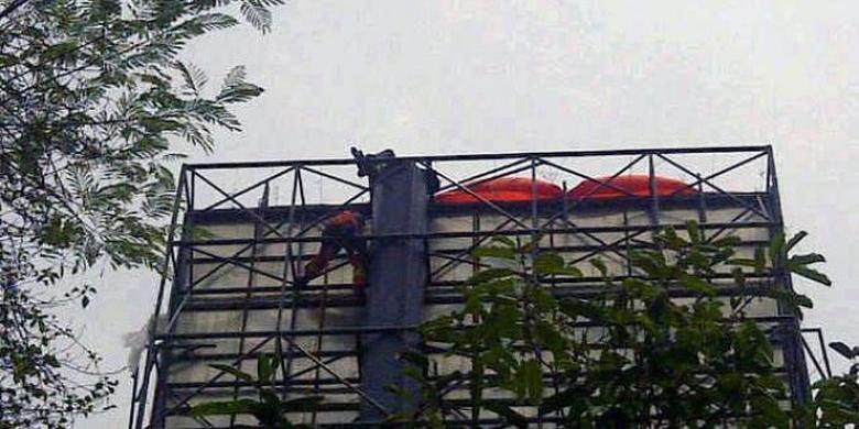 Fransiscus Agustinus memanjat papan reklame di kawasan Lebak Bulus, dekat lampu merah Point Square, Jakarta Selatan, Selasa (8/10/2013).