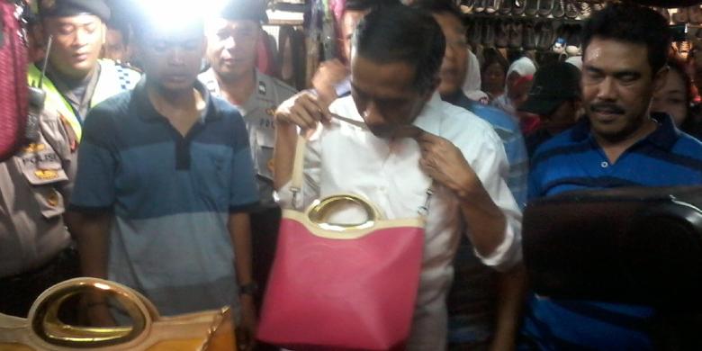 Joko Widodo (tengah), melihat tas sebelum membelinya saat berkampanye di Pasar Ramayana, Cianjur, Jawa Barat, Sabtu (29/3/2014) siang.
