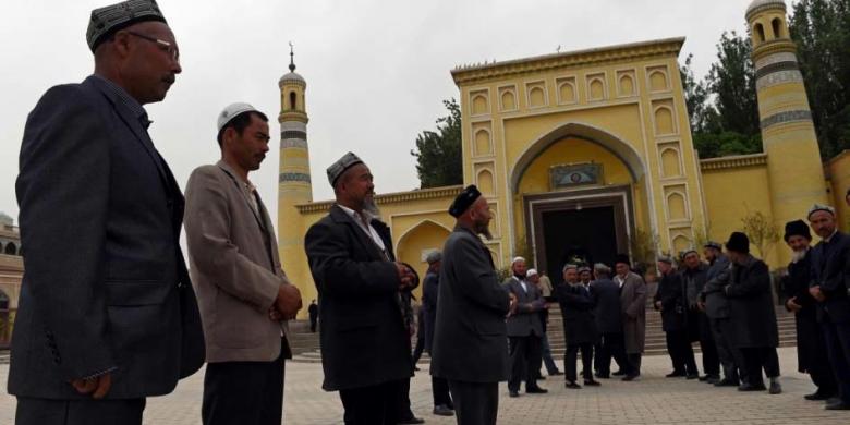  Warga Suku Uighur berkumpul usai menjalankan shalat di Masjid Id Kah di Kashgar, Xinjiang, China bagian barat, 19 April 2015. Pihak berwenang China telah membatasi ekspresi agama di Xinjiang, yang telah memicu perlawanan.(AFP PHOTO / GREG BAKER)