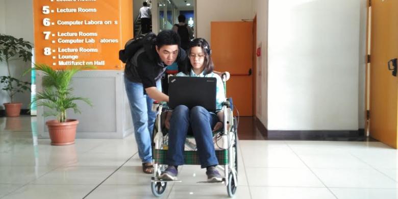 Ivan Halim Parmonangan (kiri) dan Jennifer Santoso bersama Bina Nusantara Wheelchair yang dikembangkan.