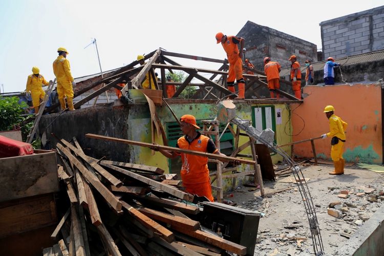 Pasukan pelangi saat menghancurkan bangunan rumah warga untuk program bedah rumah di Jalan Cilincing Lama, Cilincing, Jakarta Utara, Senin (17/4/2017). Pemprov DKI Jakarta memilih kawasan Cilincing sebagai lokasi peluncuran program bedah rumah karena wilayah tersebut merupakan salah satu kelurahan dengan jumlah masyarakat miskin terbanyak di Jakarta Utara.