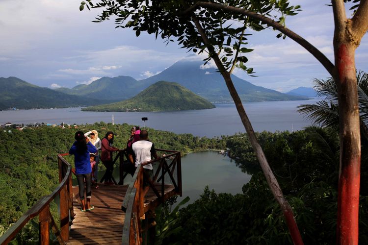 

Wisatawan sedang menikmati pemadangan Pulau Maitara, Pulau Tidore, dan Danau Laguna di Desa Fitu , Ternate.