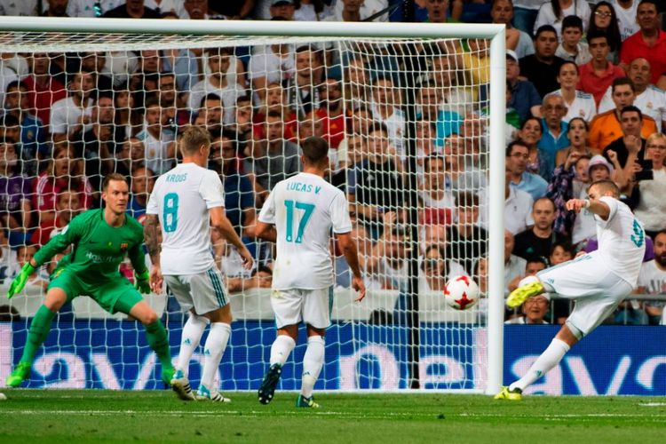 Penyerang Real Madrid, Karim Benzema, saat mencetak gol ke gawang Barcelona pada laga Piala Super Spanyol, Kamis (17/8/2017).