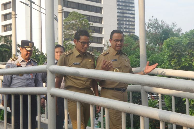 Gubernur DKI Jakarta Anies Baswedan dan Wakil Gubernur Sandiaga Uno di Halte Dukuh Atas saat akan menaiki bus transjakarta, Selasa (17/10/2017). 