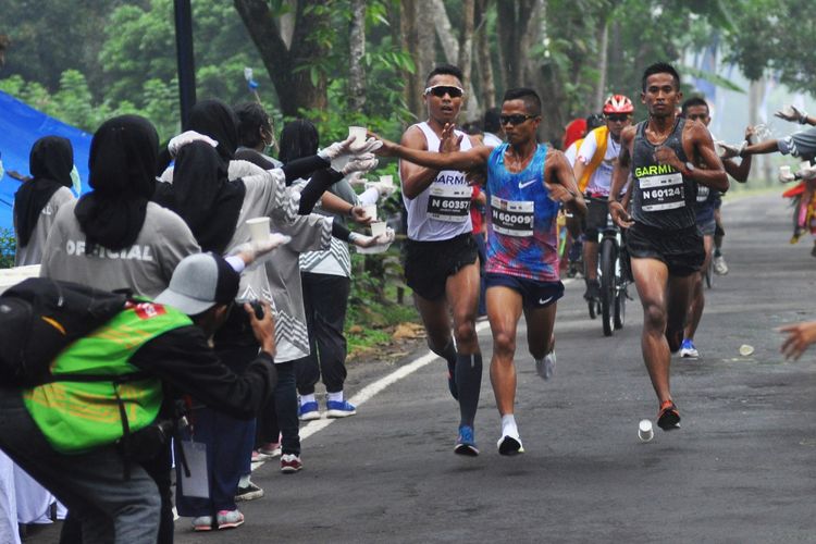 Sejumlah pelari mengambil gelas berisi menuman pada Bank Jateng Borobudur Marathon (BJBM) 2017 di Taman Wisata Candi (TWC) Borobduur, Magelang, Jateng, Minggu (19/11). Sebanyak 8.754 peserta dari dalam dan luar negeri mengikuti BJBM yang meombakan tiga kategori Full Marathon (42 km), Half Marathon (21 km) dan 10 K (10 km) dengan total hadiah sebesar Rp 2,3 miliar. ANTARA FOTO/Anis Efizudin/ama/17
