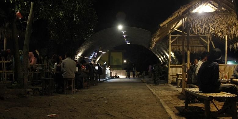 


Para pengunjung sedang menikmati makanan dan minuman sambil berbincang-bincang di Kafe Kolong, Jember, Kamis (10/9/2015). Sebelum menjadi kafe, kolong jembatan ini digunakan sebagai tempat pembuangan sampah, tempat mabuk, dan judi.